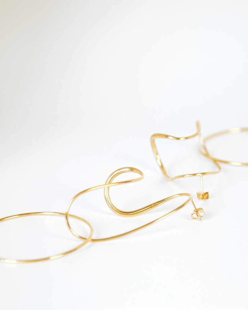 
            
                Load image into Gallery viewer, BAR Jewellery Sustainable Opposing Forms Earrings In Gold Drop Style, Placed On Ear
            
        