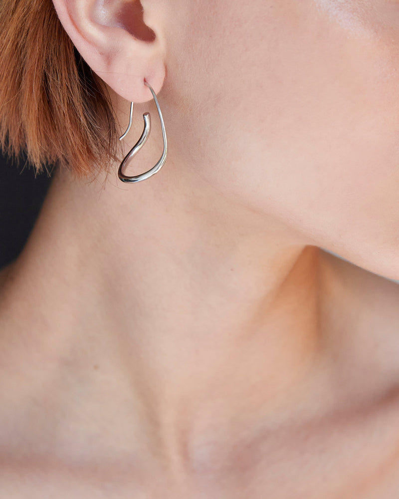 
            
                Load image into Gallery viewer, BAR Jewellery Sustainable Piega Earrings In Silver Hoop Style, Placed On Ear
            
        